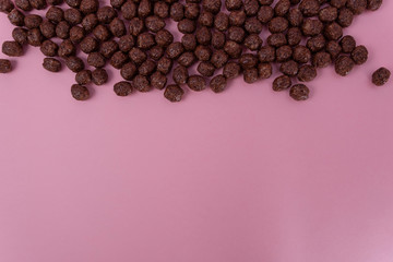 Chocolate Breakfast cereal on pink background. Top view, copy space.