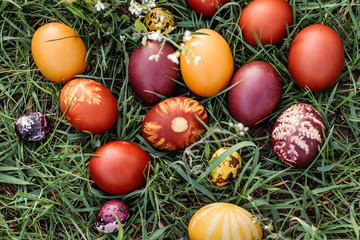 Fototapeta na wymiar Easter background, multi-colored chicken and quail eggs on bright natural grass background.
