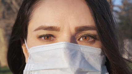 Pandemic, portrait of a woman in a protective mask on the street, close-up.