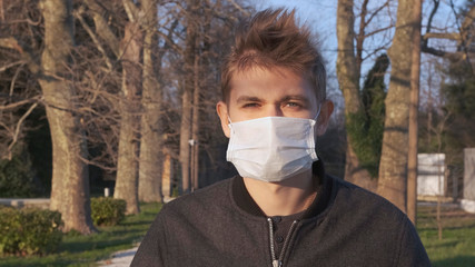 Pandemic, portrait of a man in a protective mask on the street.