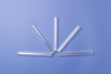 five test tubes lying a fan on blue colored paper background