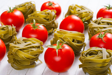 toamtoes with tagliatelle pasta on white wood table