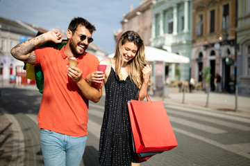 Young happy couple with shopping bags in the city, having fun together.