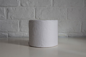 Roll of toilet paper on a white wall background.