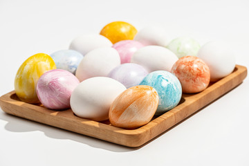  Collection of colorful Easter eggs on a wooden stand. White background.