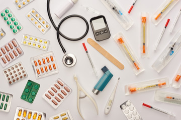 Top view of pills, syringes and medical objects on white background
