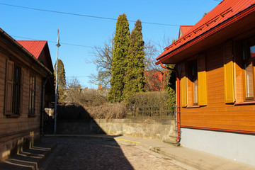 Narrow street of an old town. Paved passageway between two wooden houses. Old town building exterior.