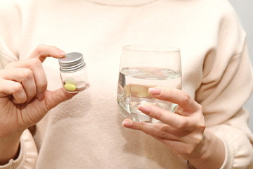 a glass of water and tablets in a glass jar in your hands