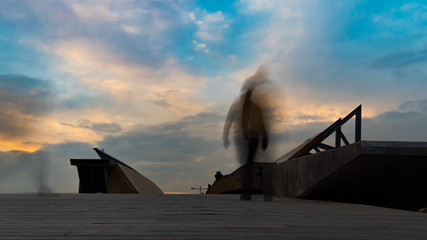 Silhouettes of people on the bridge long exposure photo. city people