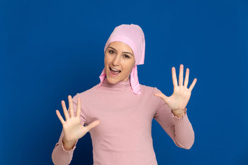 Young woman with pink scarf on the head on a blue background