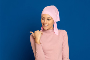 Young woman with pink scarf on the head on a blue background