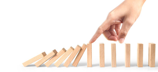 Hand stopping the Domino effect stopped by unique