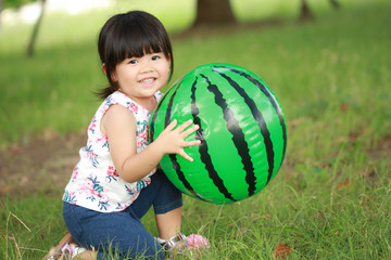 スイカのビーチボールで遊ぶ女の子