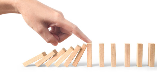 Hand stopping the Domino effect stopped by unique