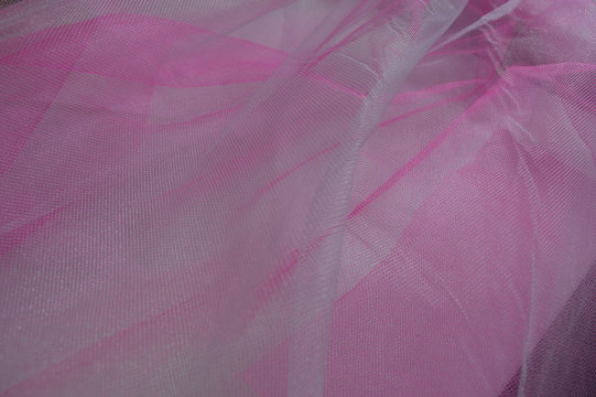Bright white and pink banground of transparent material with tiny holes