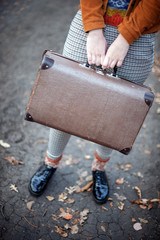 Black patent leather shoes and an old brown suitcase