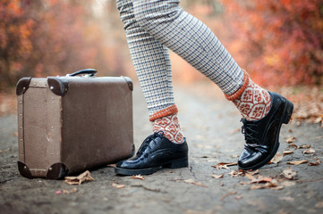 Black patent leather shoes and an old brown suitcase