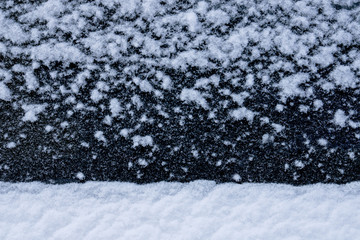 Fototapeta na wymiar Snow white flakes texture on black background as winter landscape