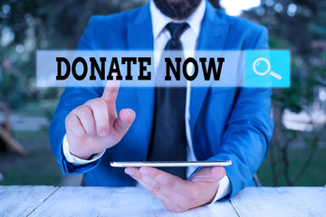 Writing note showing Donate Now. Business concept for to give something like money or goods to a...