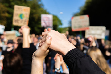 zwei Junge Menschen reichen sich die Hände im Rahmen einer Fridays for Future Demonstration und...