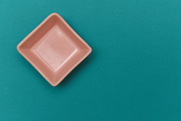 small salmon-colored ceramic bowl on a paper background
