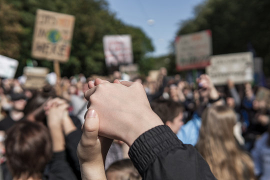 zwei Junge Menschen reichen sich die H&auml;nde im Rahmen einer Fridays for Future Demonstration und zeigen ihre Entschlossenheit