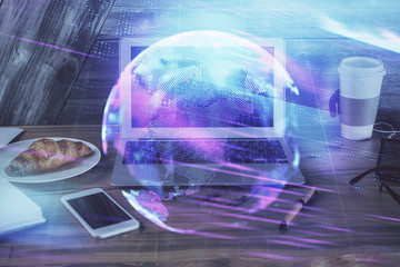 Computer on desktop in office with technology theme hologram. Multi exposure. Tech concept.