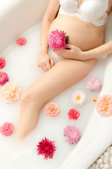 Obraz na płótnie Canvas Beautiful pregnancy in a bath with flowers