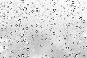 Water drops on a window glass on a winter snowy day