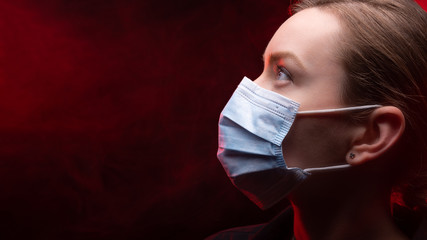 Coronavirus virus in 2020 flu, epidemic. Girl in a protection mask on a black background, Danger of...