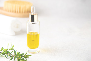 Selective focus on glass bottle with serum or massage oil, body brush