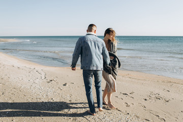 Loving couple on the seashore. Traveling and walking by the water by the sea.