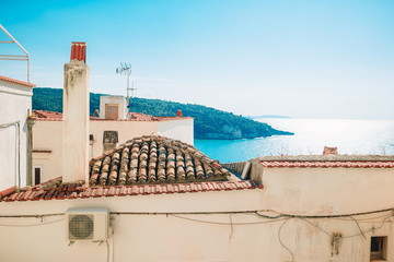The narrow streets of the island with blue balconies, stairs and flowers.