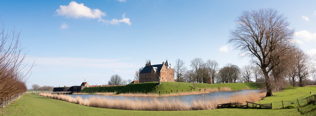Naklejka na ściany i meble castle loevestein and moat under blue sky in the netherlands near river waal