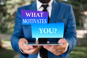 Word writing text What Motivates Youquestion. Business photo showcasing know reasons why you want to wake up each morning Businessman in blue suite with a tie holds lap top in hands