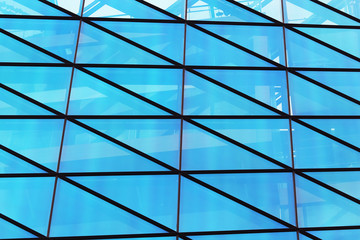 Fototapeta premium Glass window wall of modern building with blue sky reflection