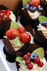 Bright cupcakes with strawberries and blueberries.