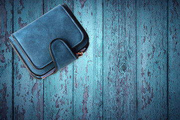 Blue women wallet isolated on blue wood background.