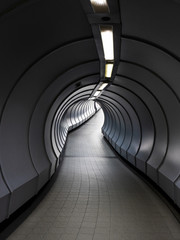 Fototapeta premium A curve pathway inside underground pedestrian crossing tunnel in Singapore.