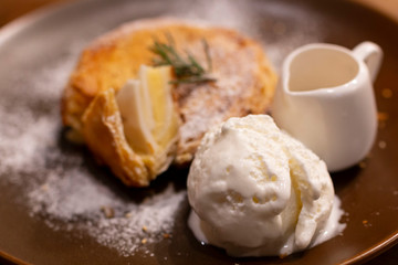 Ice Cream with coconut pie on a rustic plate with syrup. Homemade Vanilla Ice cream together with fresh make coconut pie. Selective focus of Ice Cream serve with Homemade coconut pie.