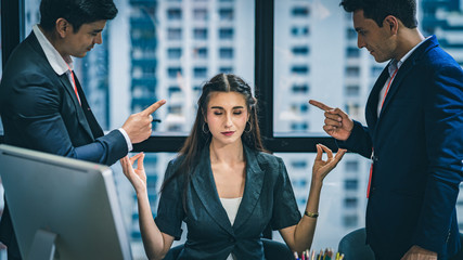 Businesswoman meditating, ignoring her supervisors from criticizing her. 