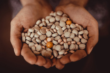 a large assortment of flu pills in hand