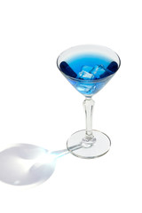 Blue Lagoon cocktail with ice cubes is contained in a martini glass. The showy illustrative picture is made on the white background.