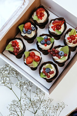 Bright cupcakes with strawberries and blueberries.