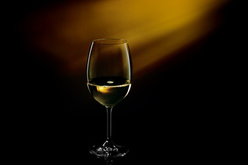 Glass filled with white wine on a gradient background. Close-up studio shot.