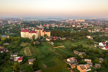 Aerial landscape of small town or village with rows of residential homes and green trees.