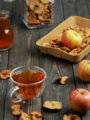 Healthy fruit drink - compote (stewed apple drink) in the cup. Dried apples and ripe apples on a dark wooden table. Close-up, space for text. Traditional homemade folk drink.