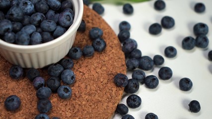 blueberries lying on the table and in a white bowl. view from the top.