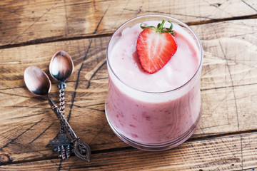 Homemade yogurt with fresh strawberries in glasses on a wooden background. Selective focus. Copy space.