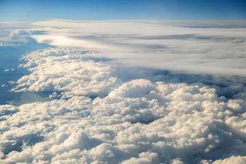 Aerial view of white puffy clouds viewed from an airplane.